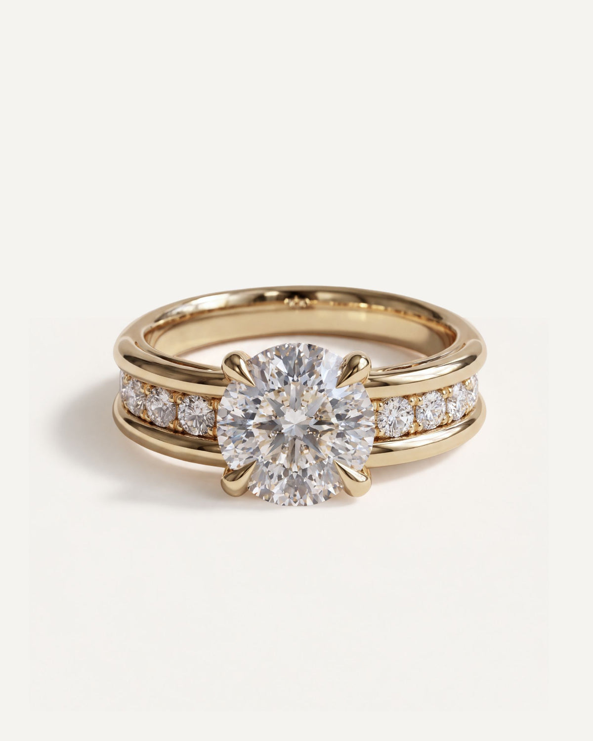 Dual Rail Solitaire Engagement Ring in 14k yellow gold, a round diamond in four claws on a band of diamonds set between two gold rails