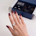 An emerald-cut try-on stone worn on the hand, with the open kit beside it