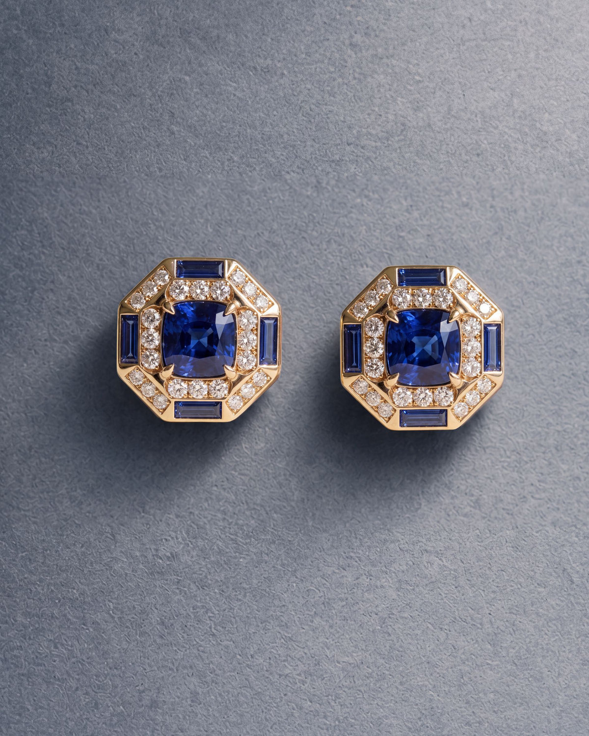 Octagon Sapphire Halo Studs from Archive I, cushion blue sapphires framed in diamonds and sapphire baguettes, on blue-grey paper