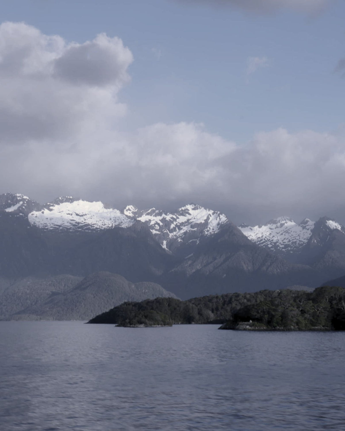 Snow-capped mountains above a still lake in New Zealand