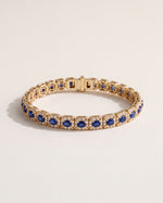 Oval Sapphire Halo Bracelet in 18k yellow gold, oval blue sapphires in leaf-shaped claws, each circled by eight round diamonds