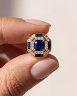Octagon Sapphire Halo Stud held between finger and thumb to show its size