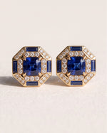 Octagon Sapphire Halo Studs in 18k yellow gold, a cushion blue sapphire framed by round diamonds and sapphire baguettes in an eight-sided border