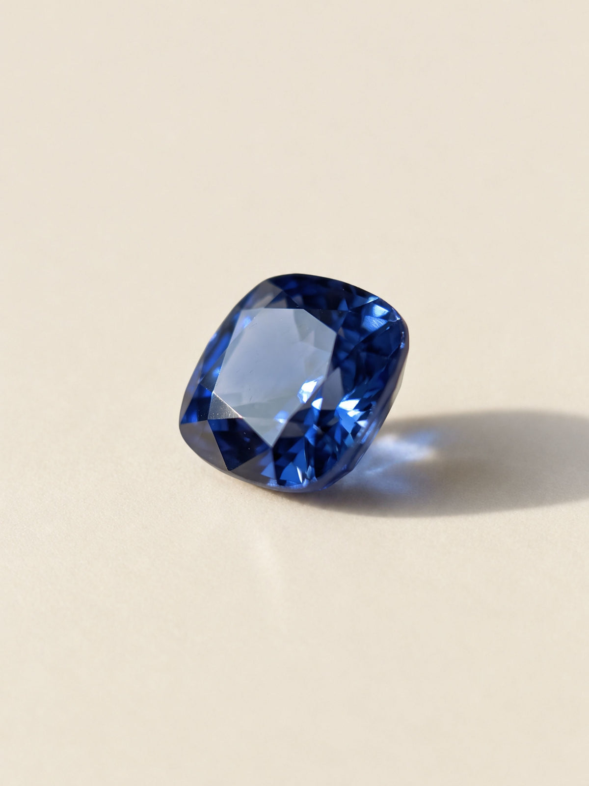 A loose cushion-cut blue sapphire, the center stone for the Octagon Sapphire Halo Studs