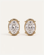 Signature Curved Diamond Studs, a pair of 1 carat oval diamonds in four claws with a curved 14k yellow gold surround