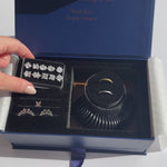 Top-down view of Ring Try-On Kit showing 10 clear stone shapes on a tray, metal setting guides, and a black ring sizer dial in a navy presentation box
